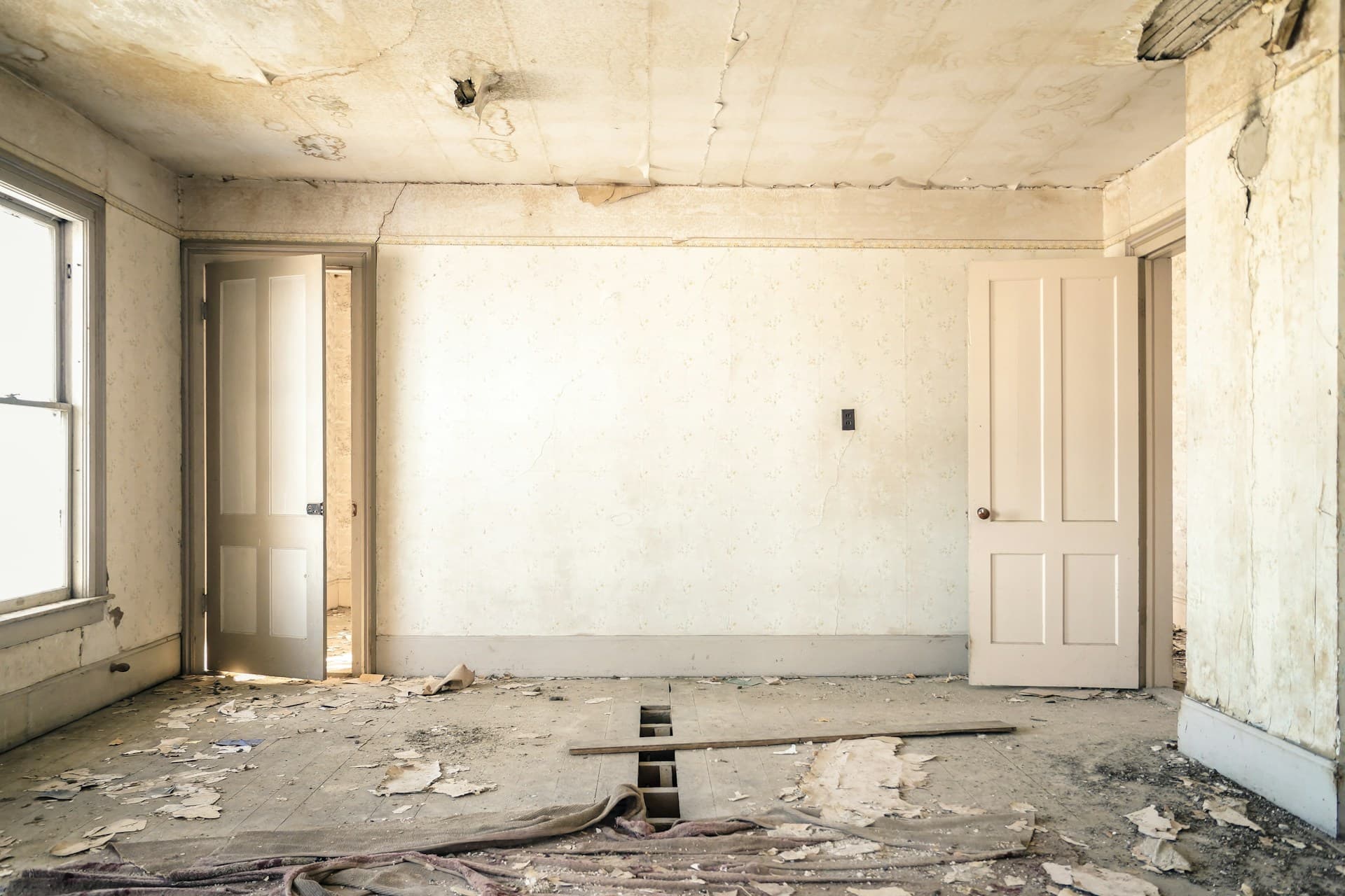 A dated living room with stained carpet and worn brown couch before Renovation AI.